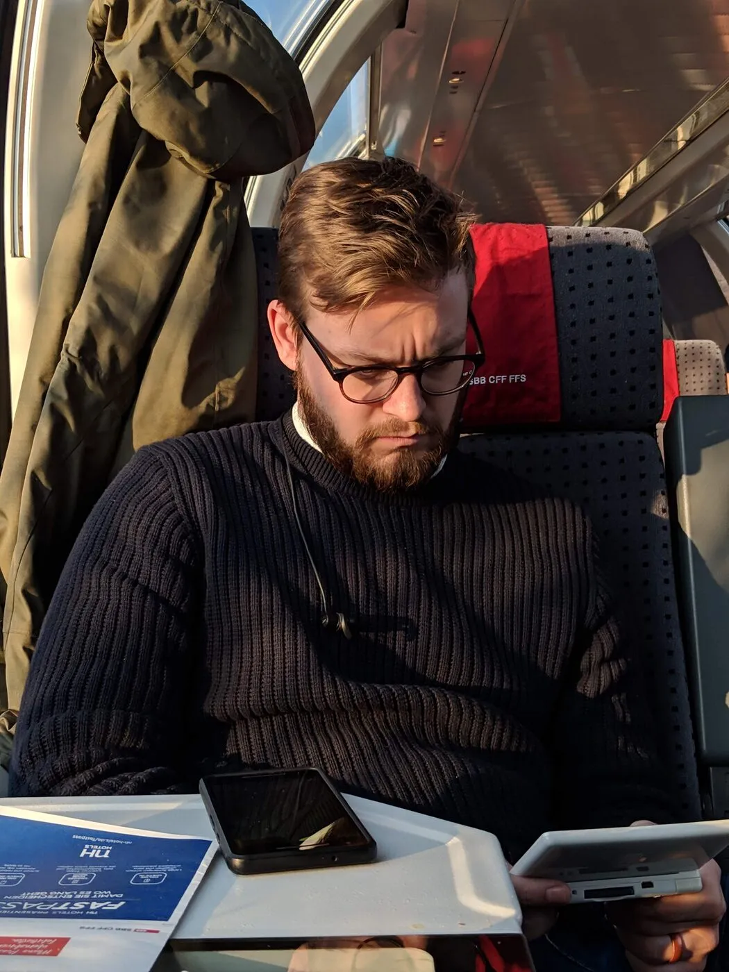 Head down, reading, on a Swiss train.